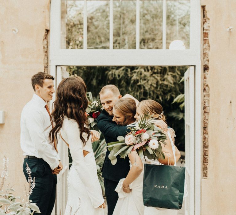 Bride and Groom Embracing Wedding Guests