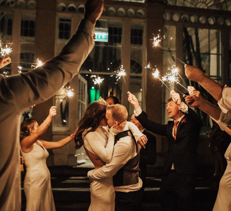 Bride and Groom Kissing During Sparkler Moment