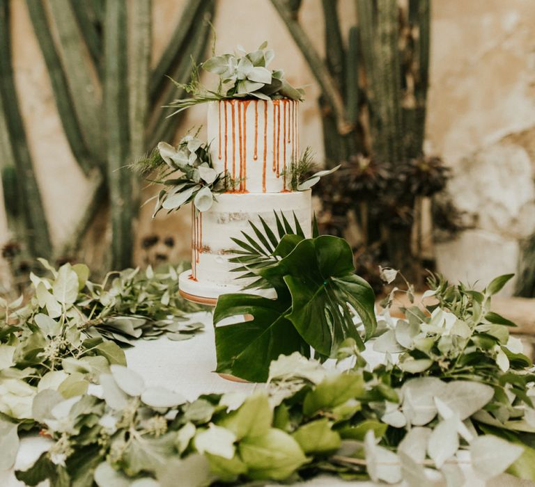 Two Tier Semi Naked Wedding Cake with Drip Decor and Greenery Backdrop