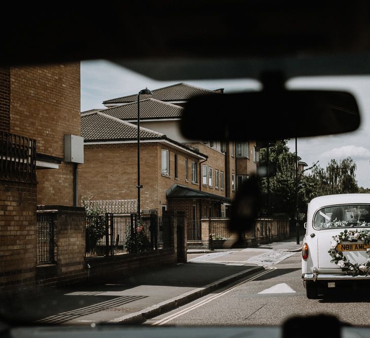 White Wedding Car with Flower Garland and Ribbons | Floral Arch and Bride in Batwing Sleeve Halfpenny Dress for London Pub Wedding | Caitlin + Jones