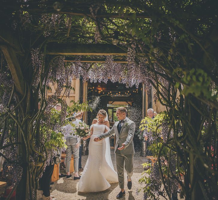 Confetti exit for bride in flat wedding shoes and groom