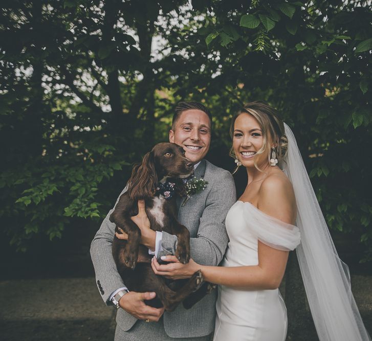 Bride and groom with their beloved pet dog at their wedding