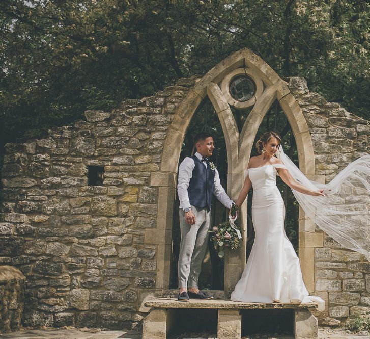 Bride wears flat wedding shoes with beautiful mermaid wedding dress from Wed2b and veil