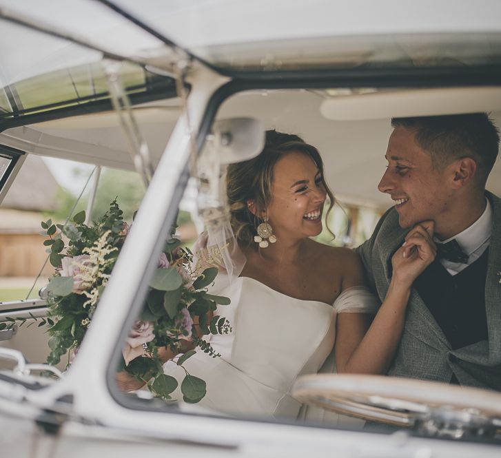 Bride and groom in VW camper van wedding transport