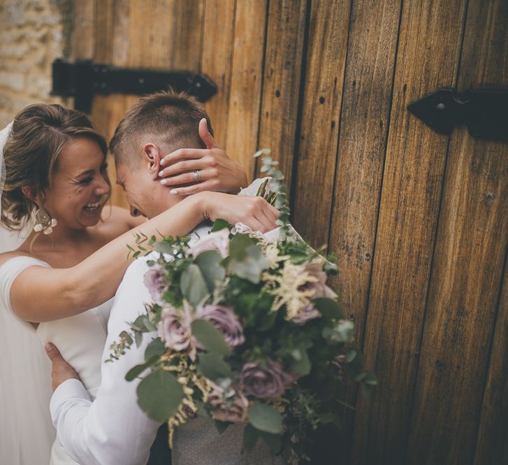 Bridal updo with veil and lilac bouquet