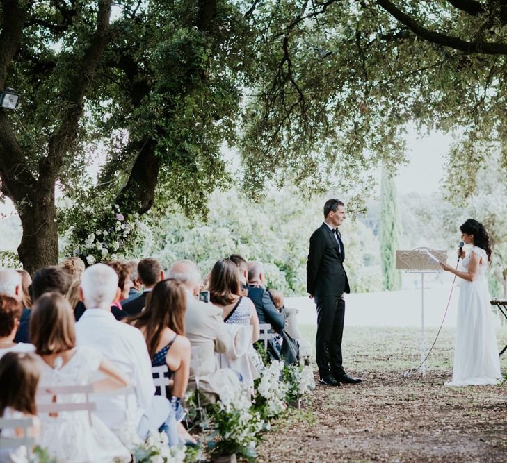 Bride in Appliqué Caroline Castigliano Wedding Dress and Groom in Black Tie Suit Exchanging Vows During Wedding Ceremony