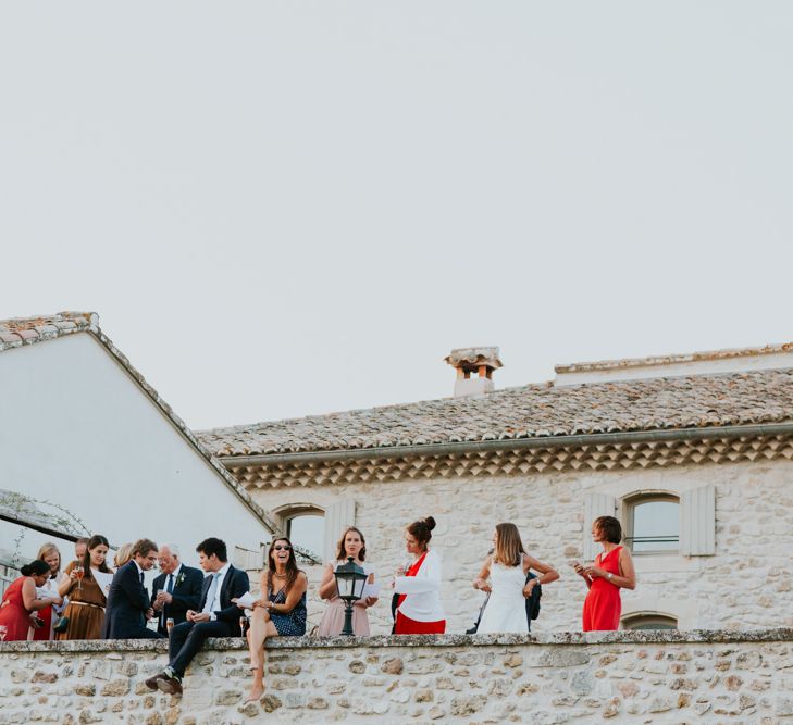 Wedding Guests Sitting on the Wall at Provence Wedding Venue