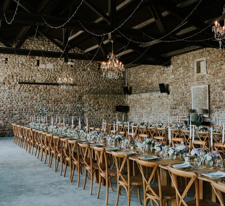 Barn Wedding Reception with Chandeliers, Wooden Table and Candle Sticks