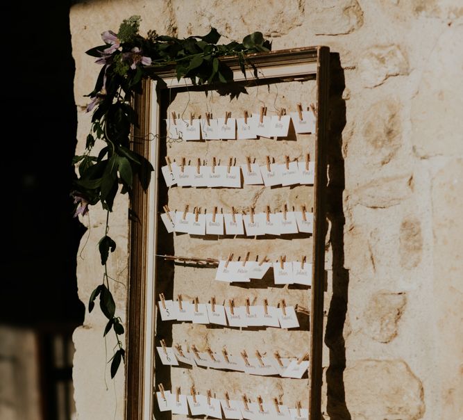 Escort Cards Pinned Up on Ornate Wedding Frame