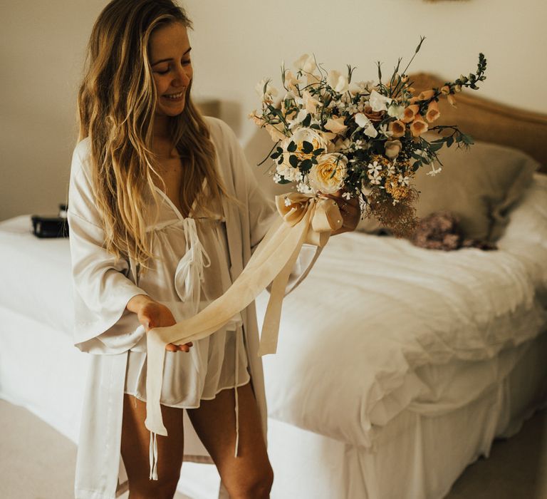 Bride Holding Wedding Bouquet of Mixed Flowers with Champagne Trailing Ribbon | Outdoor Ceremony at Fishley Hall with Grace Loves Lace Fringe Dress | Darina Stoda Photography