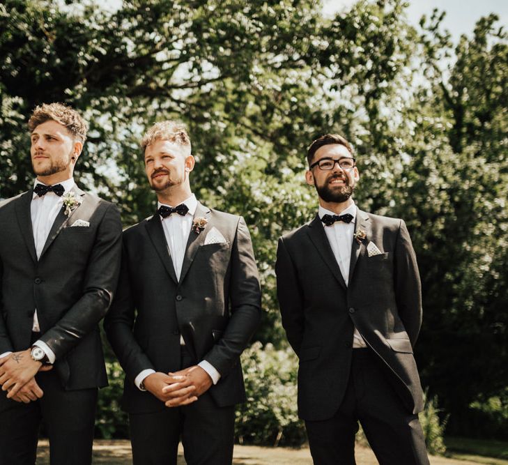 Groom Waiting For His Bride | Groom and Groomsmen in Black Gagliardi Suits with Bow Tie and Braces | Outdoor Ceremony at Fishley Hall with Grace Loves Lace Fringe Dress | Darina Stoda Photography