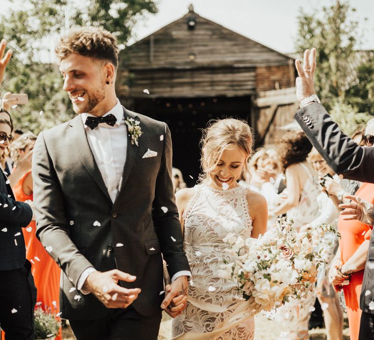 Just Married | Confetti Throw | Bride in Embroidered Grace Loves Lace Gown with Fringing and Cut Out Back | Groom in Black Gagliardi Suit with Bow Tie and Braces | Wedding Bouquet of Mixed Ochre and White Flowers with Champagne Trailing Ribbon | Outdoor Ceremony at Fishley Hall with Grace Loves Lace Fringe Dress | Darina Stoda Photography