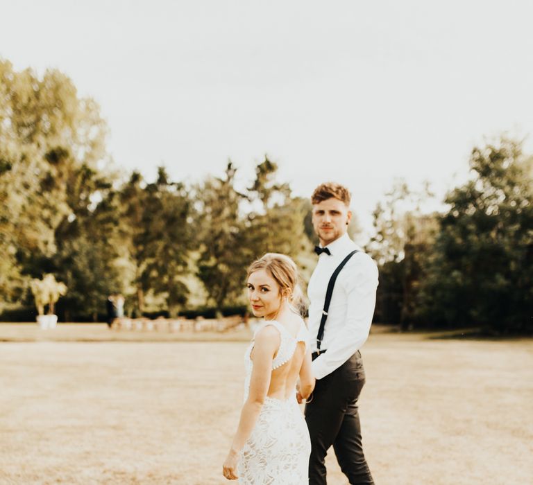 Bride in Embroidered Grace Loves Lace Gown with Fringing and Cut Out Back | Groom in Black Gagliardi Suit with Bow Tie and Braces | Outdoor Ceremony at Fishley Hall with Grace Loves Lace Fringe Dress | Darina Stoda Photography