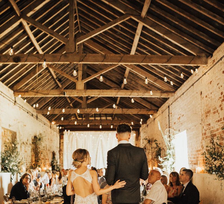 Bride and Groom Speech | Bride in Embroidered Grace Loves Lace Gown with Fringing and Cut Out Back | Groom in Black Gagliardi Suit with Bow Tie and Braces | Festoon Lights | Outdoor Ceremony at Fishley Hall with Grace Loves Lace Fringe Dress | Darina Stoda Photography