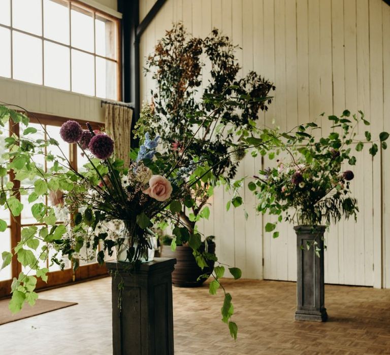 Wildflower arrangements on plinths at Soho Farmhouse Wedding