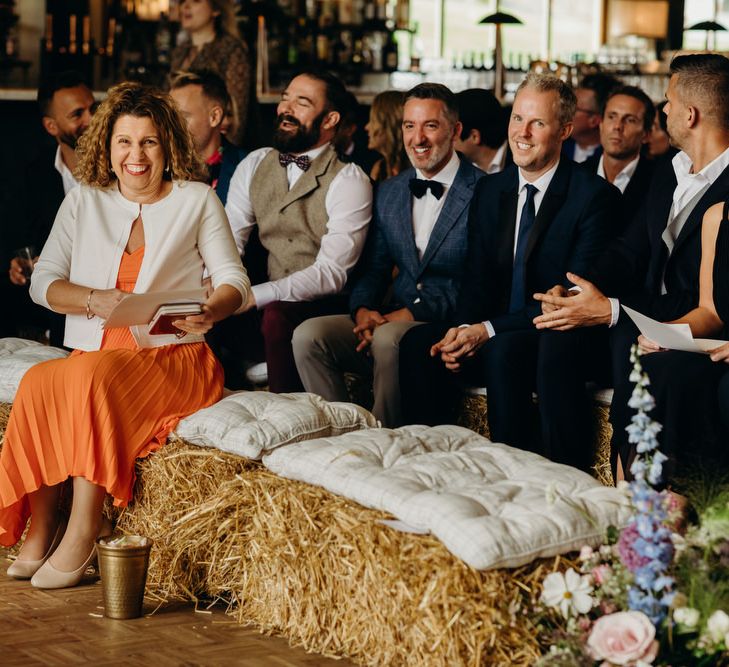 Guests Sitting on Hay Bales at Ceremony