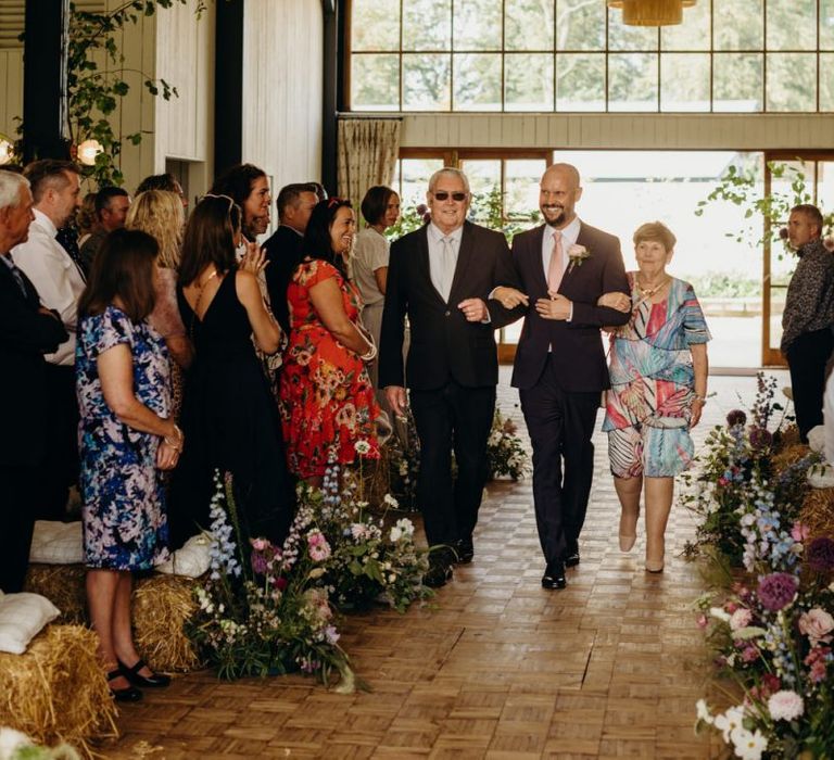 Groom Walking Down the Aisle with His Parents during the Ceremony