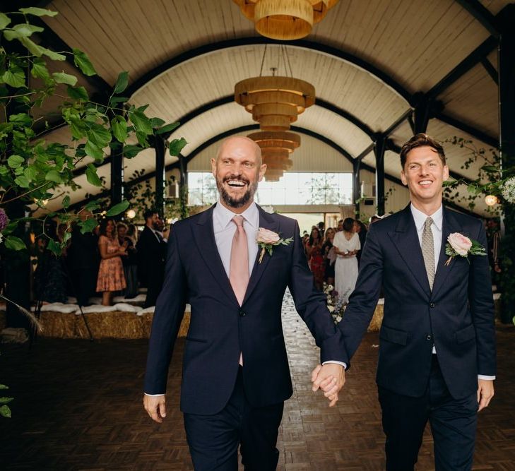 Groom and Groom Holding Hands after the Nuptials