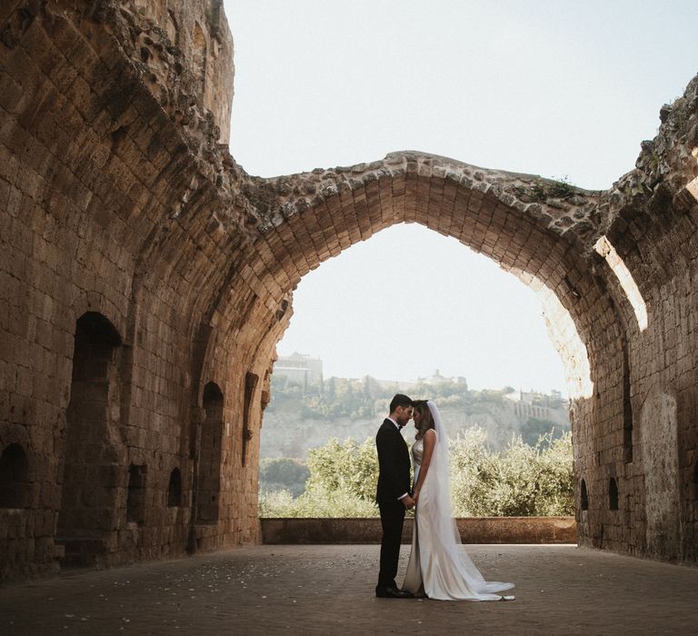 Bride in Silk Pallas Couture Wedding Dress with Plunging Neckline and Side Split | Roman &amp; French Cathedral Veil | Salvatore Ferragamo Nude Bridal Shoes | Groom in Made to Measure Tuxedo Suit by Oscar Hunt | Black Aquila Shoes | Intimate Italian Castle Wedding with Prosecco Tower | James Frost Photography