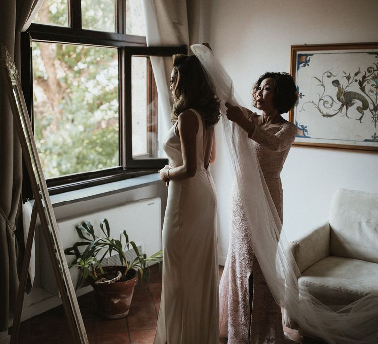 Bride Getting Into Her Gown | Silk Pallas Couture Wedding Dress with Plunging Neckline and Side Split | Roman &amp; French Cathedral Veil | Mother of the Bride in Blush Pink Lace Dress | Intimate Italian Castle Wedding with Prosecco Tower | James Frost Photography