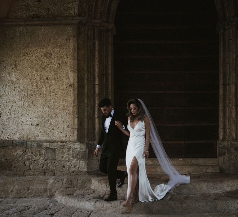 Bride in Silk Pallas Couture Wedding Dress with Plunging Neckline and Side Split | Roman &amp; French Cathedral Veil | Salvatore Ferragamo Nude Bridal Shoes | Groom in Made to Measure Tuxedo Suit by Oscar Hunt | Black Aquila Shoes | Intimate Italian Castle Wedding with Prosecco Tower | James Frost Photography