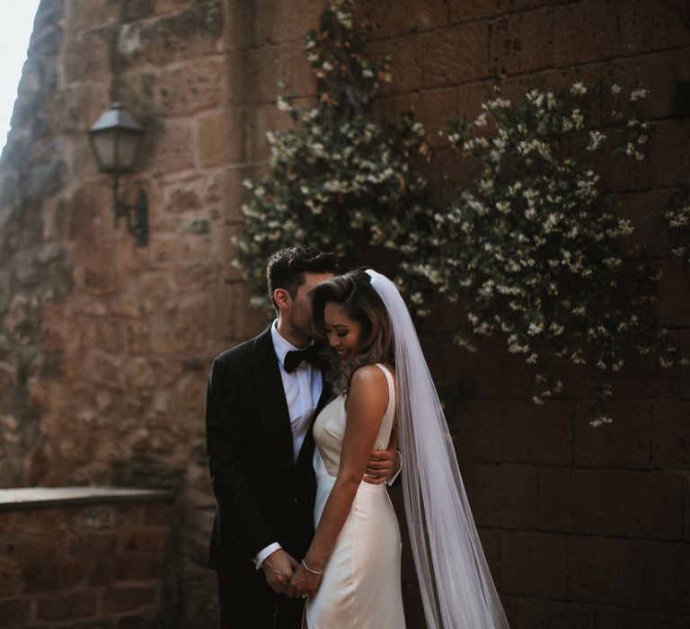 Bride in Silk Pallas Couture Wedding Dress with Plunging Neckline and Side Split | Roman &amp; French Cathedral Veil | Groom in Made to Measure Tuxedo Suit by Oscar Hunt | Intimate Italian Castle Wedding with Prosecco Tower | James Frost Photography