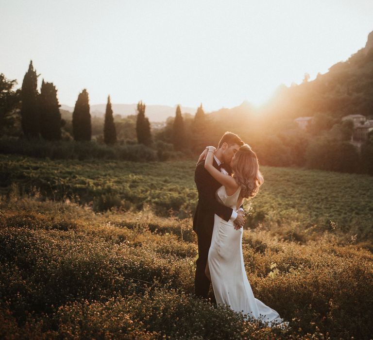 Bride in Silk Pallas Couture Wedding Dress with Plunging Neckline and Side Split | Groom in Made to Measure Tuxedo Suit by Oscar Hunt | Intimate Italian Castle Wedding with Prosecco Tower | James Frost Photography