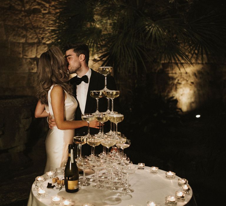 Prosecco Tower | Coupe Glasses | Tea Lights | Bride in Silk Pallas Couture Wedding Dress with Plunging Neckline and Side Split | Groom in Made to Measure Tuxedo Suit by Oscar Hunt | Intimate Italian Castle Wedding with Prosecco Tower | James Frost Photography