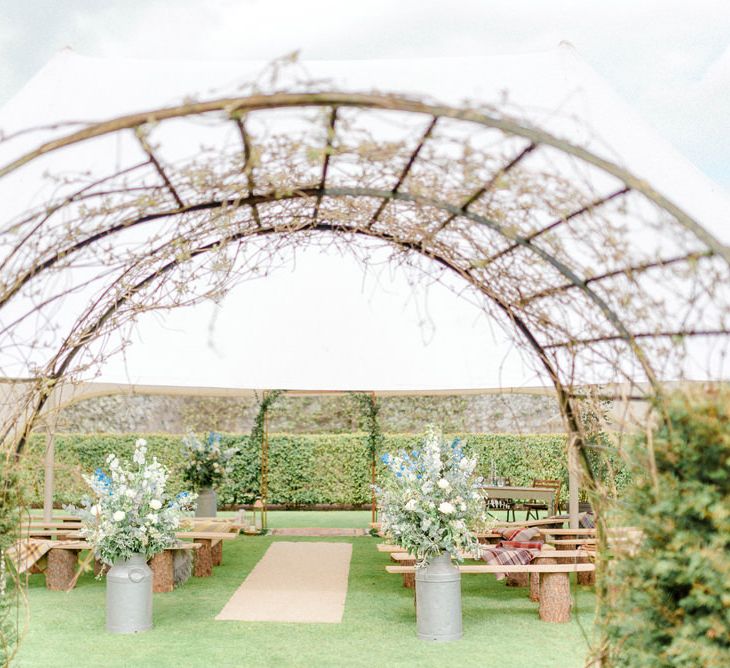 Wedding Ceremony Set Up with Flower Filled Milk Churns and Benches Wedding Decor