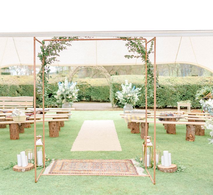 Wedding Ceremony Set up with Copper Fram Altar, Persian Rugs, Benches and Flower Filled Milk Churns