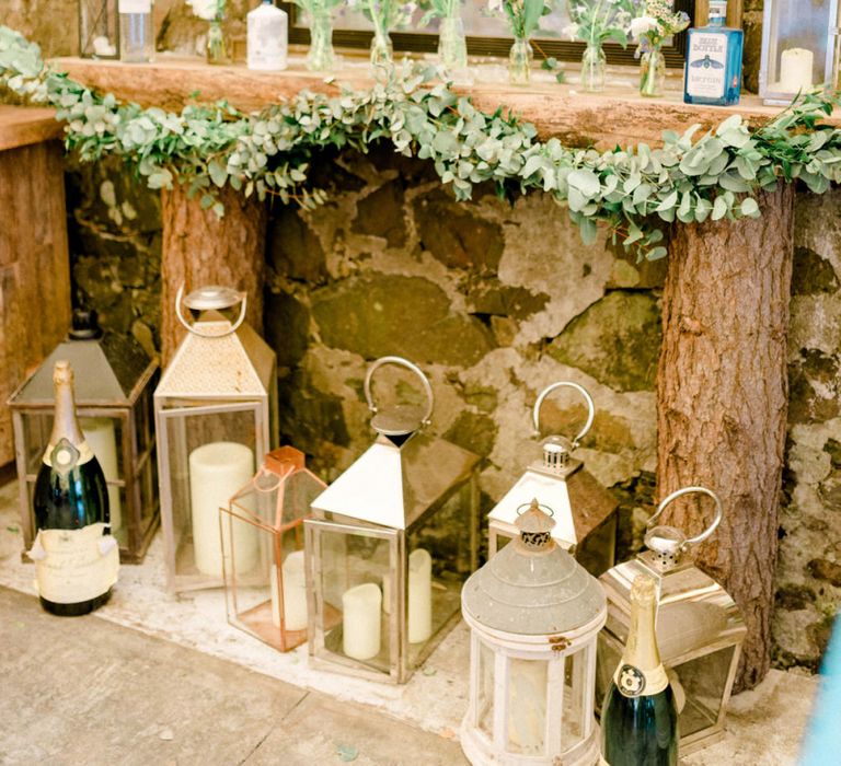 Faux Fireplace made of Logs with Mirror and Storm Lanterns Wedding Decor