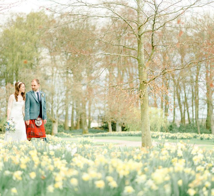 Bride and Groom Walking Through a Bed of Daffodils