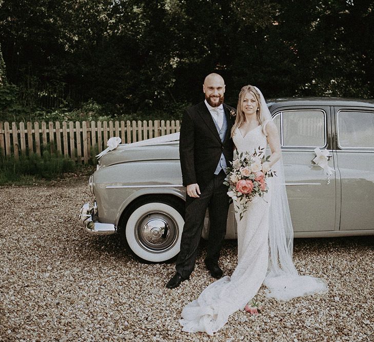 Bride &amp; Groom In Front of Vintage Sage Green Wedding Car