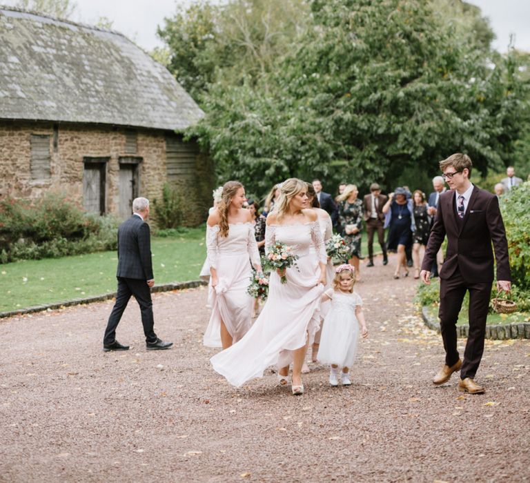 Wedding Party Walking Across The  Venue Courtyard