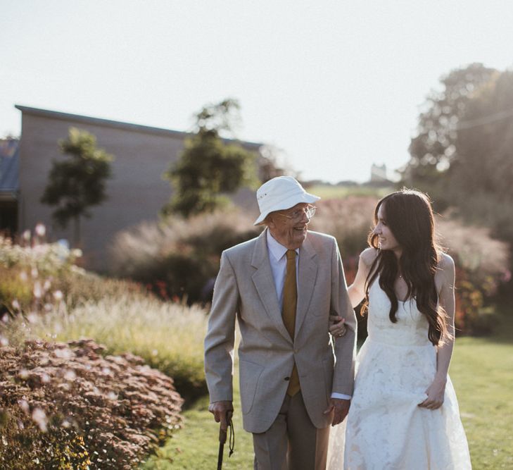 Bride Strolls Through Venue Grounds With Guest