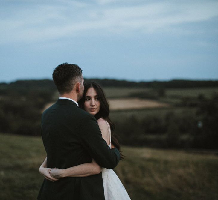 Bride and Groom Embrace In Venue Grounds