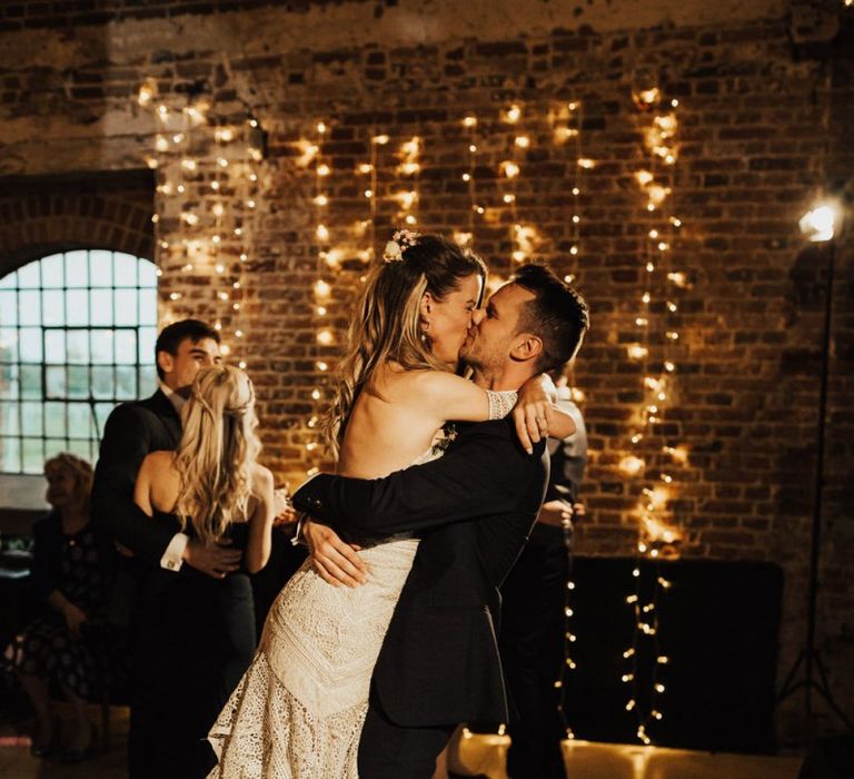 Groom Picking Up His Bride and Kissing Her on the Dance Floor