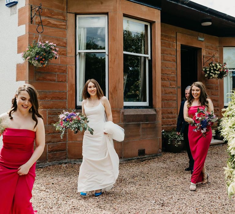 Bride and bridesmaids in red dresses leaving the house