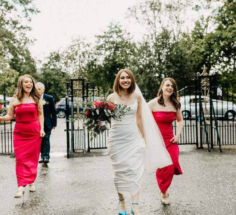 Bride and bridesmaids in red dresses entering the church