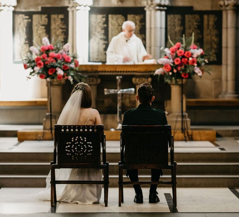 Bride and groom sitting at the altar at Glasgow University Chapel  wedding ceremony