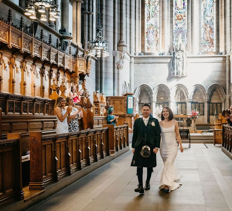 Bride and groom walking up the aisle as husband and wife