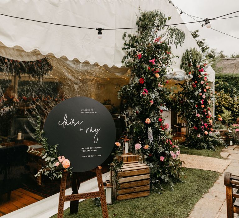 Marquee reception with round black welcome sign