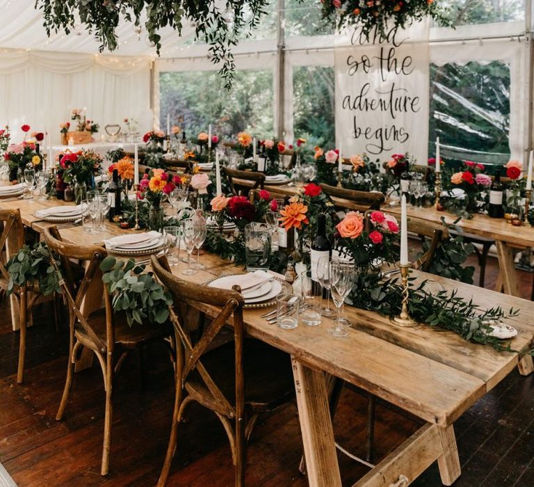 Socially distanced marquee reception with colourful flower decor