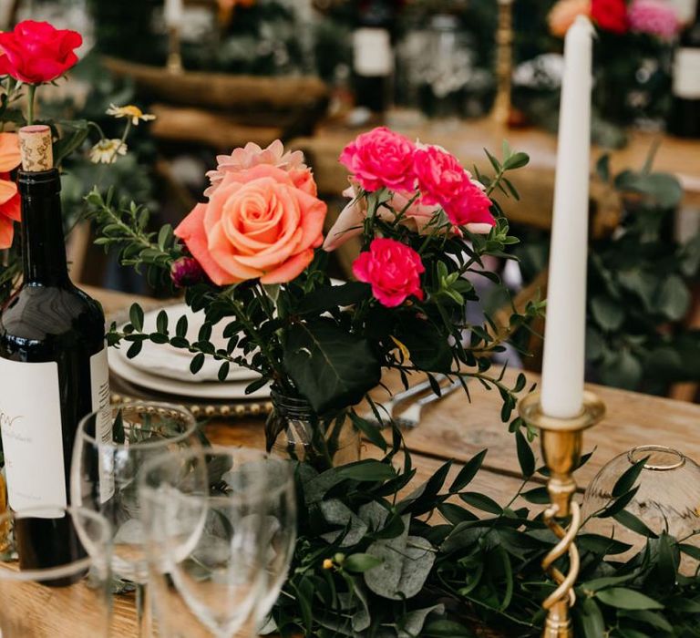 Gold candlesticks and colourful flowers at marquee reception