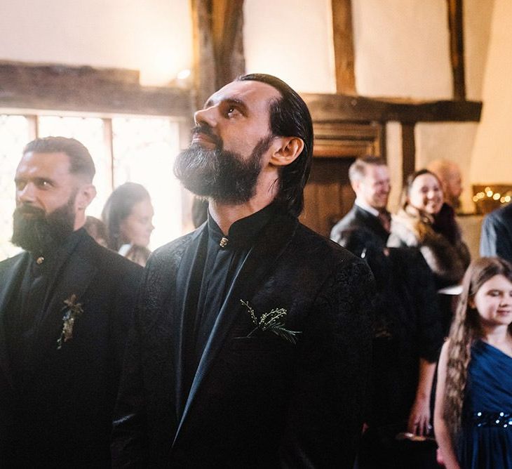 Groom wearing black jacquard suit at Gothic wedding  with cosy styling and foliage