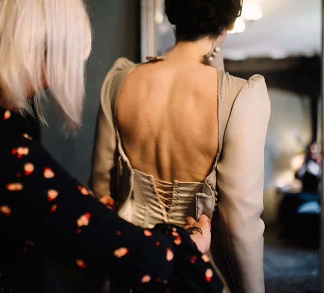 Back of brides silver dress with corset style detailing and long sleeves