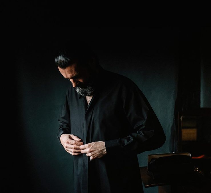 Groom getting ready for gothic styled wedding with open fire