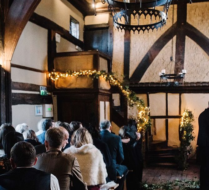 Gothic styled wedding ceremony with foliage decor and fairy lights