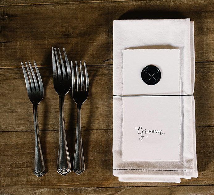 Personalised place settings at gothic wedding with candlelights and foliage decor