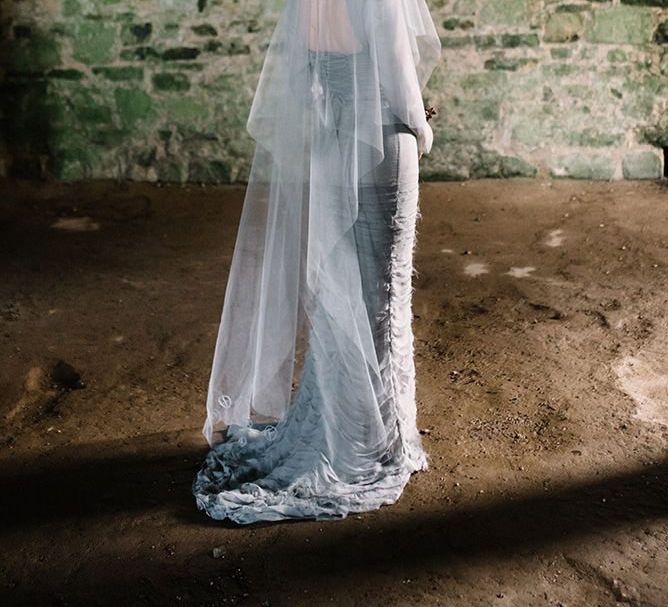 Bride wearing silver gothic styled dress with corset waist, cob-web train and floral headpiece